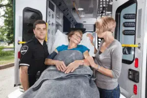 Anziana in ambulanza con medici e familiari
