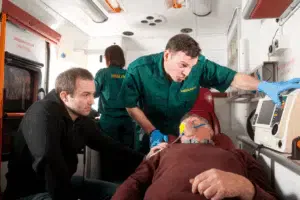 Soccorritori assistono paziente in ambulanza.