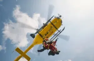 Elicottero giallo di soccorso con operatori.